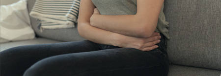 nainen pitää vatsastaan ​​kiinni