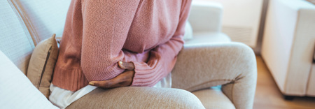 Kuukautissarky nainen pitelee vatsaansa